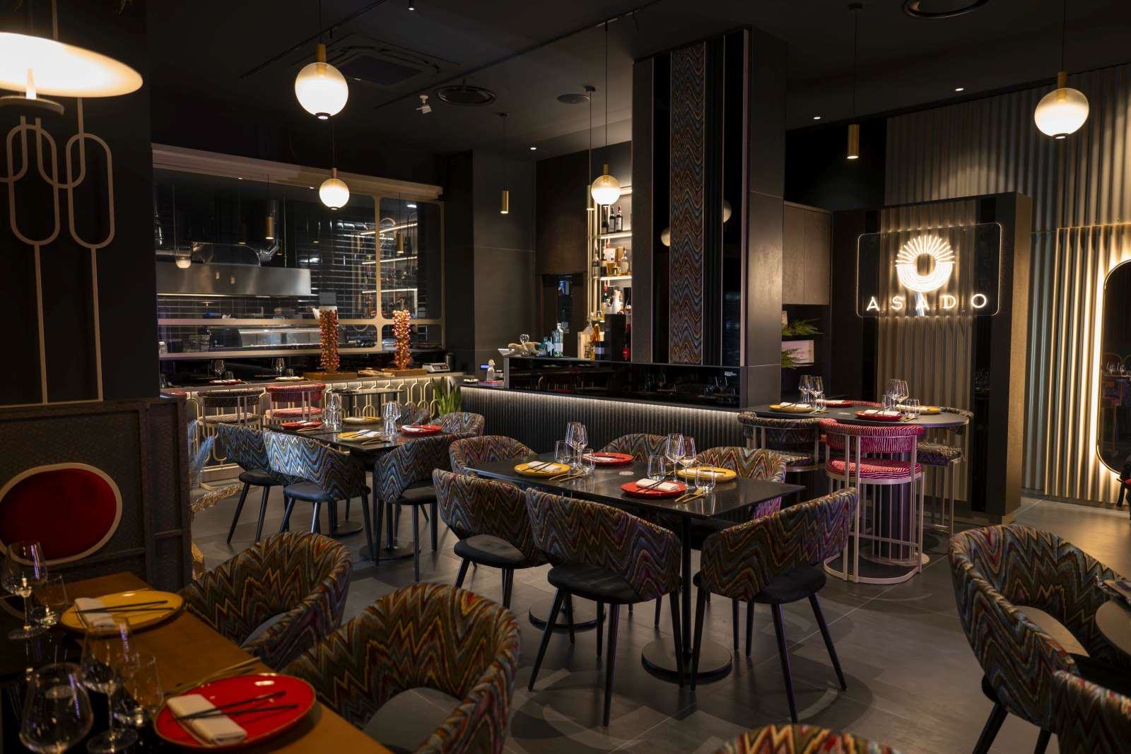 La sala con le sedie a zig zag, il bancone e la cucina a vista
